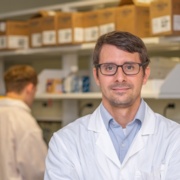 Andrew Olive stands in his lab.