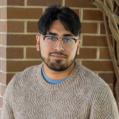 Bobby Zuniga smiles at the camera. He's in an outdoor setting.