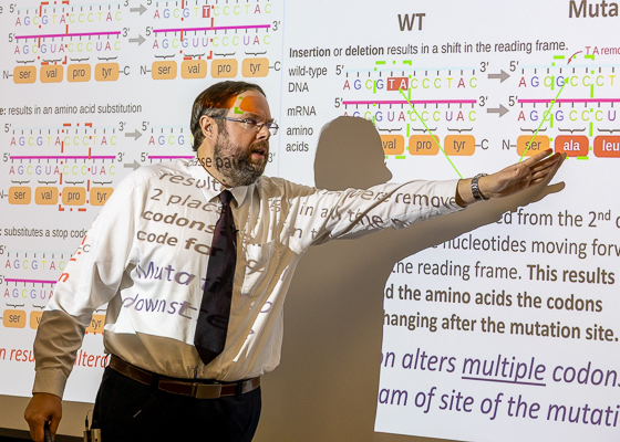 Assistant Professor Phillip Delekta teaches MGI 301. The image shows him pointing to a slide. 